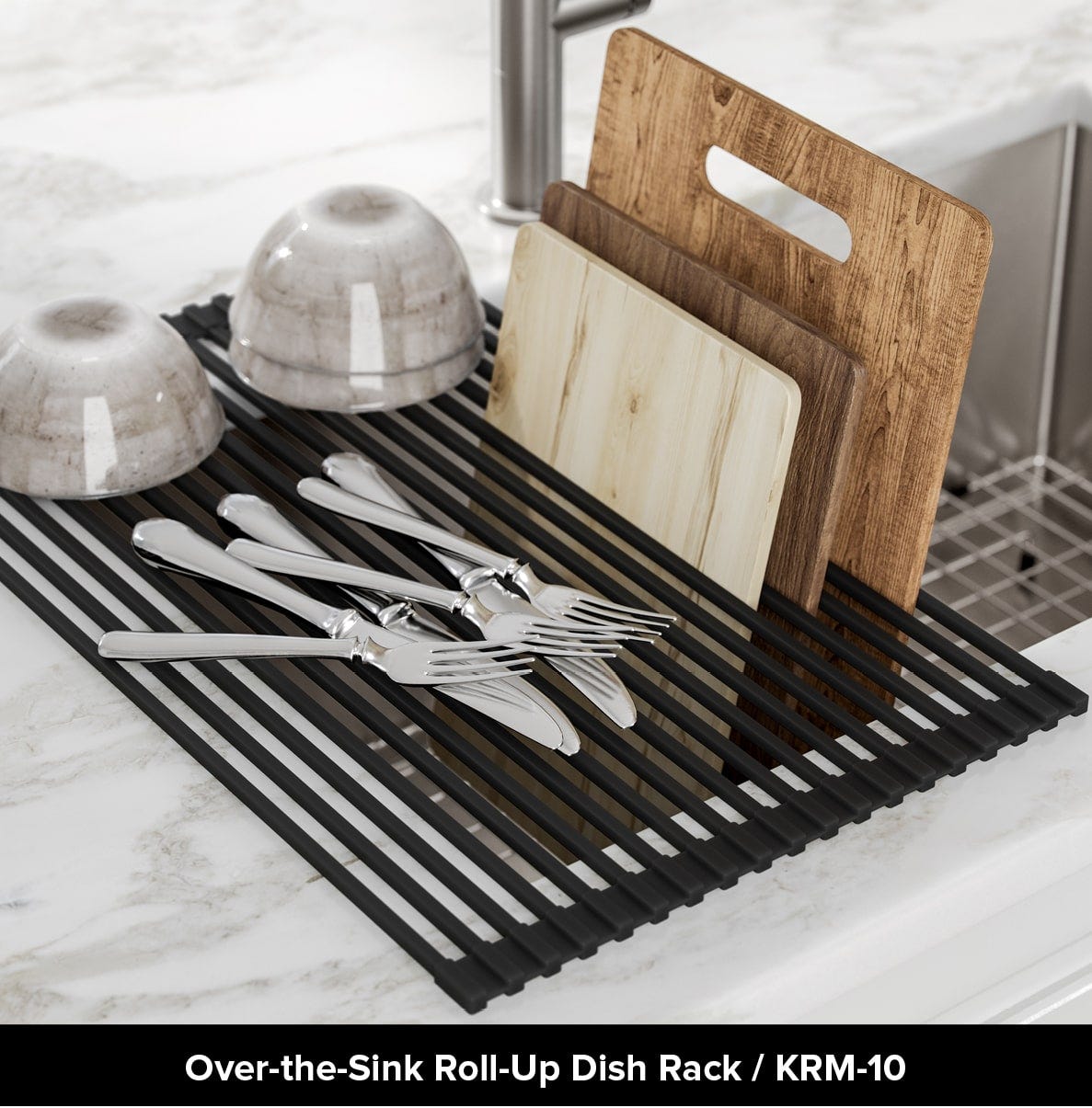 Kraus over-the-sink roll-up dish rack in black on white counter over undermount sink with utensils, cups, and cutting boards