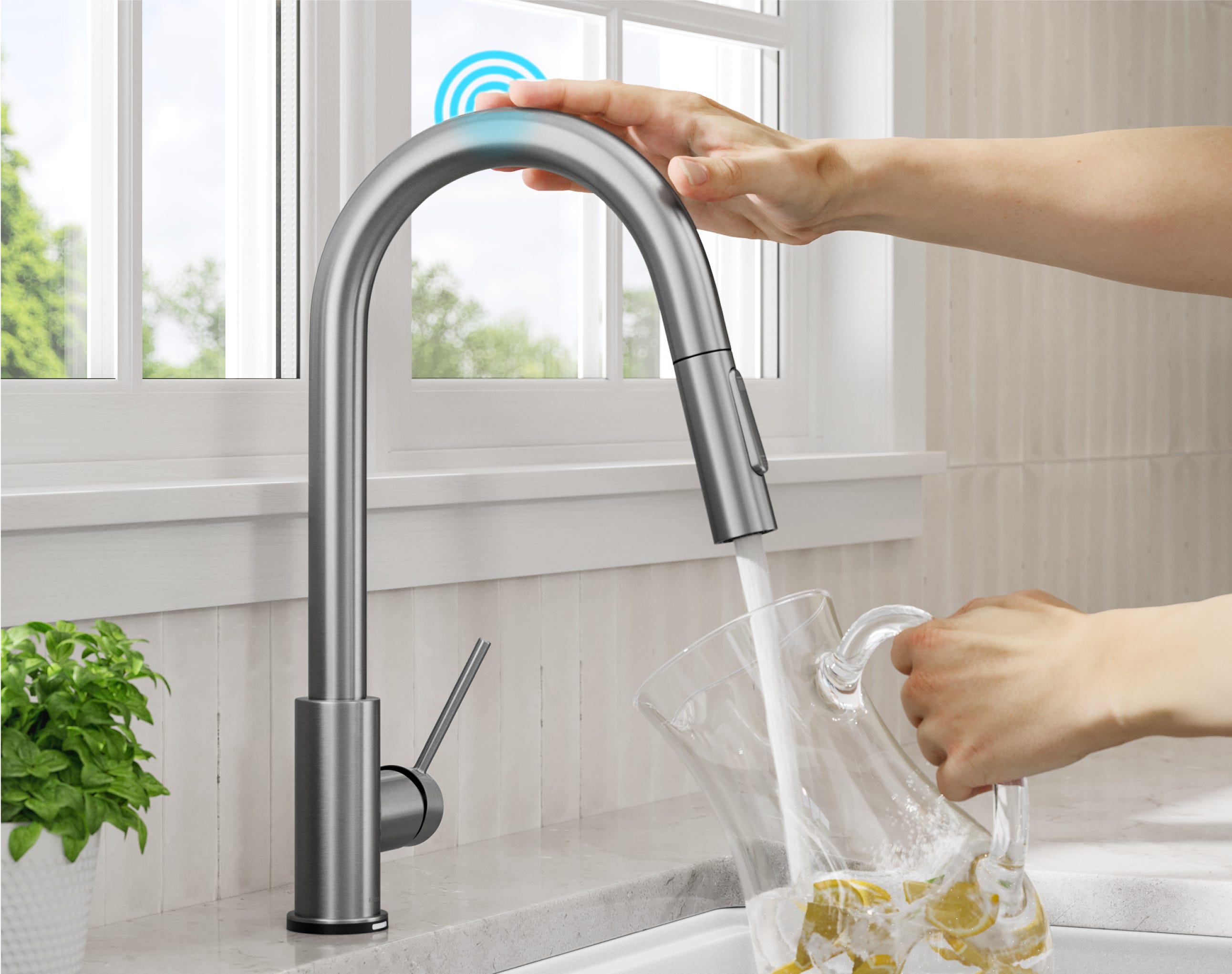  Hand touching the top of Oletto Chrome Touch Kitchen Faucet to get a pitcher of water